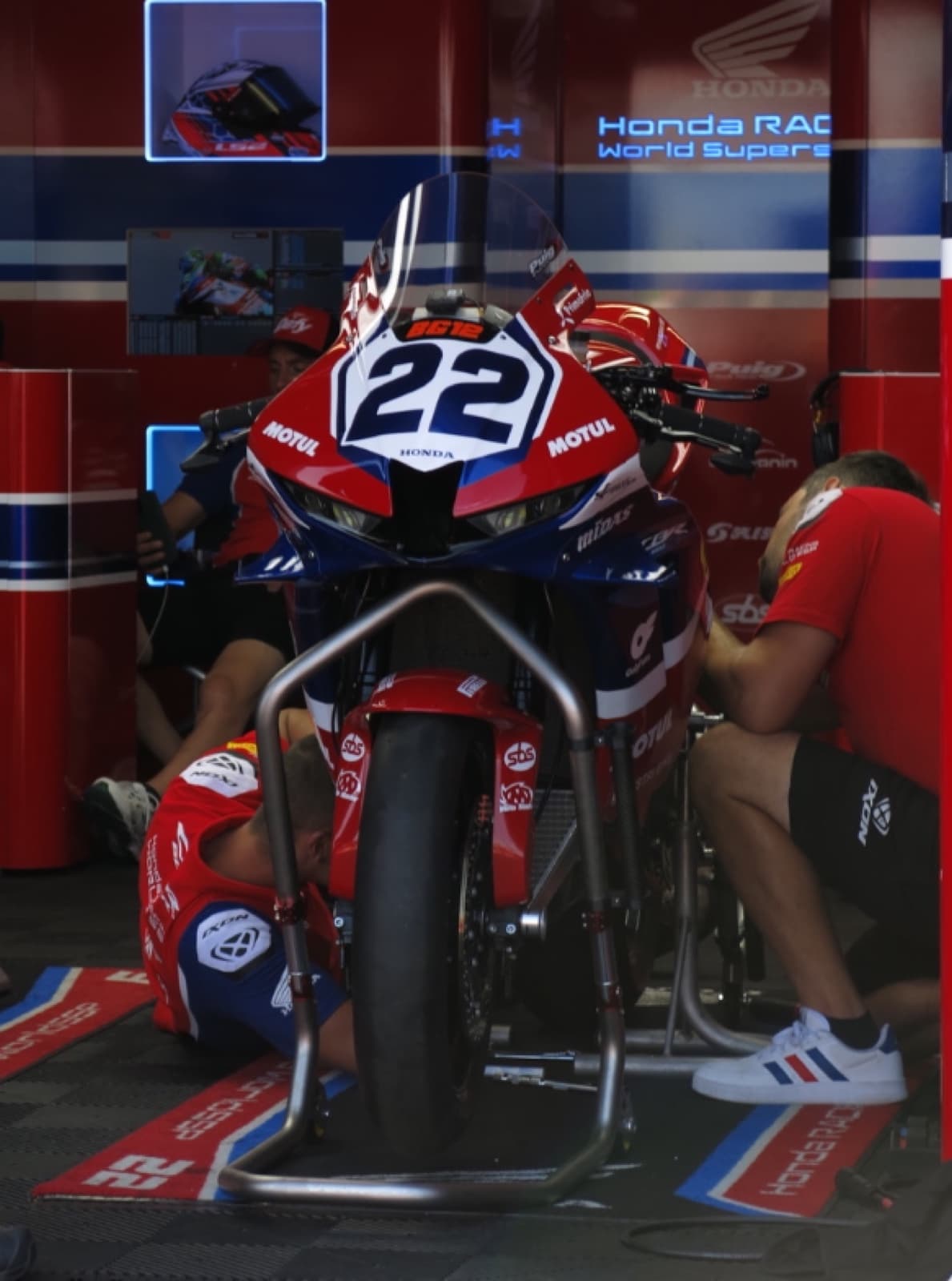 A racing team preparing a motorcycle inside the paddock