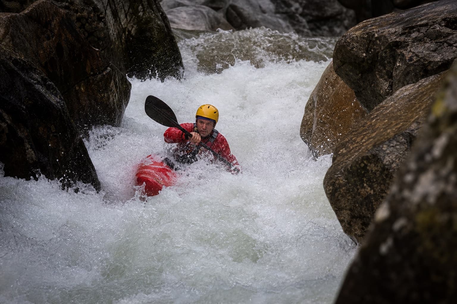 Whitewater kayaker driving through a powerful rapid