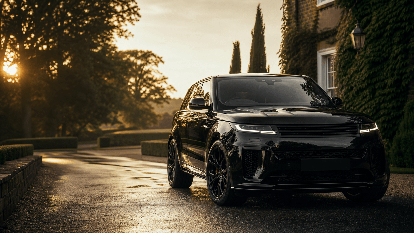 Black luxury SUV photographed on a wet country estate driveway