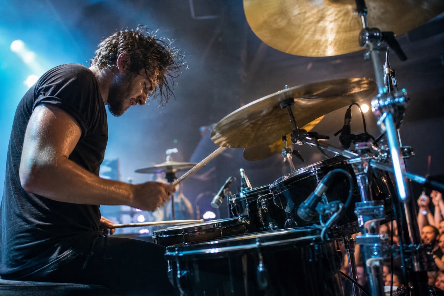 Drummer performing under vivid concert lighting