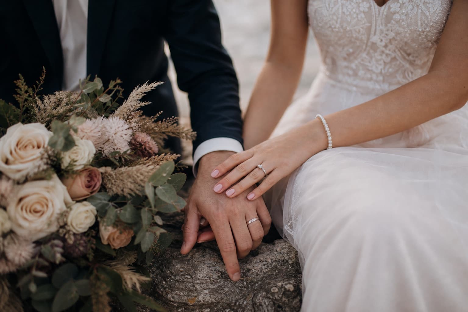 Wedding rings, flowers and hands captured in a quiet candid moment